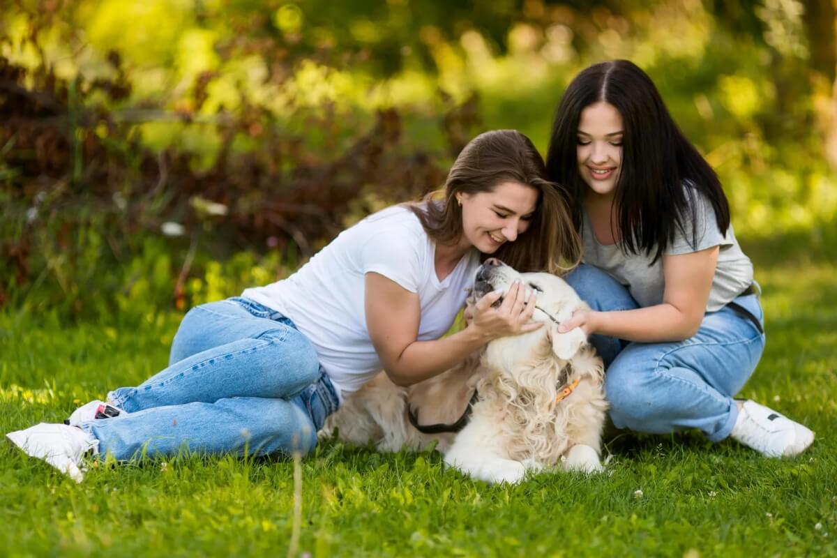 two-beautiful-women-playing-with-dog Two Beautiful Women Playing With Dogs